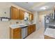 Efficient kitchen with wood cabinetry, stainless steel dishwasher, and adjacent laundry area at 130 Overcreek Rd, Mooresville, NC 28117