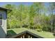 Well-maintained backyard with lush green lawn, mature trees, and a partial view from a wooden deck at 1306 Kings Bottom Dr, Fort Mill, SC 29715