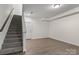 View of a finished basement, featuring stairs, wood floors, and two white doors at 133 Capital Ave # B, Mooresville, NC 28117