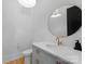 Chic powder room features modern fixtures, gray vanity with marble counter and hardwood floors at 1446 Townes Rd, Charlotte, NC 28209