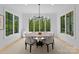 Bright dining room with contemporary chandelier, surrounded by large windows overlooking lush greenery at 1446 Townes Rd, Charlotte, NC 28209