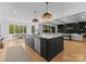 Open concept kitchen features a large central island, stainless steel appliances, and hardwood floors at 1446 Townes Rd, Charlotte, NC 28209