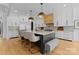 Modern kitchen featuring white cabinets, a gray island with seating, and stainless steel appliances at 1446 Townes Rd, Charlotte, NC 28209