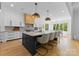 Spacious eat-in kitchen with island bar, modern light fixtures and hardwood floors at 1446 Townes Rd, Charlotte, NC 28209