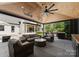 Inviting covered outdoor living area with lounge seating, ceiling fan, and outdoor kitchen with grill at 1446 Townes Rd, Charlotte, NC 28209