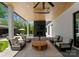 Beautiful covered patio with a fireplace and comfortable seating around a coffee table at 1446 Townes Rd, Charlotte, NC 28209