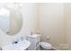 Compact powder room featuring a pedestal sink, round mirror, and neutral decor at 1540 Coatsworth Ln, Rock Hill, SC 29732