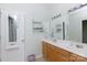 Bright bathroom featuring double sinks, oak cabinets, and a large mirror at 1540 Coatsworth Ln, Rock Hill, SC 29732