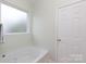 Well-lit bathroom with frosted glass window, white bathtub, and simple fixtures at 1540 Coatsworth Ln, Rock Hill, SC 29732