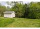 Backyard view of a shed with natural landscaping and a lush green lawn at 1540 Coatsworth Ln, Rock Hill, SC 29732