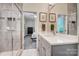 Modern bathroom featuring gray vanity, quartz countertop, and tiled shower, with an open view to the bedroom at 17315 Langston Dr, Charlotte, NC 28278