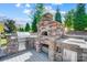 Beautiful brick outdoor kitchen with a grill and a pizza oven, a true outdoor cooking experience at 17315 Langston Dr, Charlotte, NC 28278