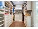 Spacious walk-in closet with custom shelves, window, and wooden floors at 17315 Langston Dr, Charlotte, NC 28278