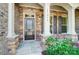 Inviting front porch with stone accents, dark door, and decorative plants at 17315 Langston Dr, Charlotte, NC 28278