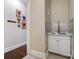 Laundry room with sink, white cabinets, tiled backsplash, and access to the hall at 17315 Langston Dr, Charlotte, NC 28278