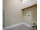 Functional laundry room with upper cabinets, gray tile flooring, and utility connections at 17315 Langston Dr, Charlotte, NC 28278