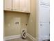Convenient laundry room with upper cabinets, dryer connections, and access to the exterior door at 17315 Langston Dr, Charlotte, NC 28278