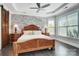 Inviting main bedroom featuring a brick accent wall, tray ceiling, and a large window at 17315 Langston Dr, Charlotte, NC 28278