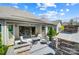 Outdoor living space with a built in brick oven, chairs surrounding an outdoor fireplace, perfect for entertaining at 17315 Langston Dr, Charlotte, NC 28278