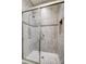Walk-in shower featuring clear glass doors, tile surround, shower head, and built-in niche for storage at 17315 Langston Dr, Charlotte, NC 28278