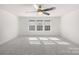 A spacious room with a ceiling fan and three large windows at 17413 Caddy Ct, Charlotte, NC 28278