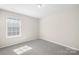 Serene bedroom with soft gray carpet and large window showcasing ample natural light and peaceful ambiance at 17413 Caddy Ct, Charlotte, NC 28278