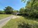 Quaint, overgrown exterior with an attached carport and mature trees, perfect for renovation, ready for new owners at 191 S Main St, Richburg, SC 29729