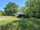Quaint, overgrown exterior with an attached carport and mature trees, ripe for renovation and revitalization at 191 S Main St, Richburg, SC 29729
