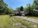 Quaint, overgrown exterior with an attached carport and mature trees, awaiting renovation and rejuvenation at 191 S Main St, Richburg, SC 29729
