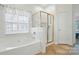 Bright bathroom with a soaking tub and a gold-trimmed glass shower enclosure with tile and a light brown tiled floor at 212 Kilborne Rd, Mooresville, NC 28117