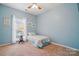 Light blue bedroom featuring neutral walls, carpet, ceiling fan and a single bed by a window, offering a serene retreat at 212 Kilborne Rd, Mooresville, NC 28117