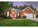 Inviting brick home with a red door, manicured lawn, and an attached two-car garage at 212 Kilborne Rd, Mooresville, NC 28117
