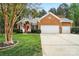 Charming brick home features an attached garage and well-manicured front lawn at 212 Kilborne Rd, Mooresville, NC 28117