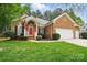 Charming brick home featuring a well-manicured lawn, an attached two car garage, and a vibrant red front door at 212 Kilborne Rd, Mooresville, NC 28117