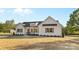 Exterior front view of a modern farmhouse with wood columns and a large yard at 215 Scout Rd, Locust, NC 28097