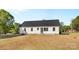 Exterior view of the rear of the property with white siding, dark roof and large yard at 215 Scout Rd, Locust, NC 28097