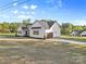 View of home featuring two-car attached garage, professional landscaping, and white siding at 215 Scout Rd, Locust, NC 28097