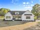 Charming one-story home featuring a light-colored exterior, complemented by wood accents and professional landscaping at 215 Scout Rd, Locust, NC 28097