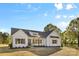 Charming one-story home featuring a light-colored exterior, complemented by wood accents and professional landscaping at 215 Scout Rd, Locust, NC 28097