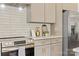 This kitchen features a stainless steel oven, neutral cabinets with gold hardware, and white subway tile backsplash at 215 Scout Rd, Locust, NC 28097