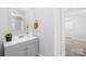 Bathroom featuring grey vanity and mirror with marble style tile surround in shower at 221 Palmer St, Albemarle, NC 28001