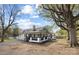 Side view of a white house with a covered porch and mature trees in a spacious yard at 221 Palmer St, Albemarle, NC 28001