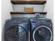 Modern laundry room with front loading washer and dryer, and wooden shelves at 221 Palmer St, Albemarle, NC 28001