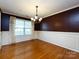 Traditional dining room features hardwood floors, dark accent wall, and wainscoting at 2316 Highland Park Dr, Charlotte, NC 28269