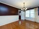Dining room featuring hardwood floors, a modern chandelier, and wainscoting at 2316 Highland Park Dr, Charlotte, NC 28269