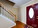 Foyer featuring a striking red door, hardwood floors, and staircase with white railings at 2316 Highland Park Dr, Charlotte, NC 28269