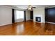 Cozy living room featuring a fireplace, ceiling fan, and gleaming hardwood floors at 2316 Highland Park Dr, Charlotte, NC 28269