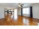 Bright living room featuring hardwood floors, ceiling fan, and views into the kitchen at 2316 Highland Park Dr, Charlotte, NC 28269