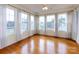 Light-filled sunroom with gleaming hardwood floors and multiple windows at 2316 Highland Park Dr, Charlotte, NC 28269