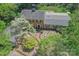 Beautiful aerial view showcasing the brick home, lush landscaping, and expansive lot surrounded by trees at 3232 Kale Ln, Matthews, NC 28105